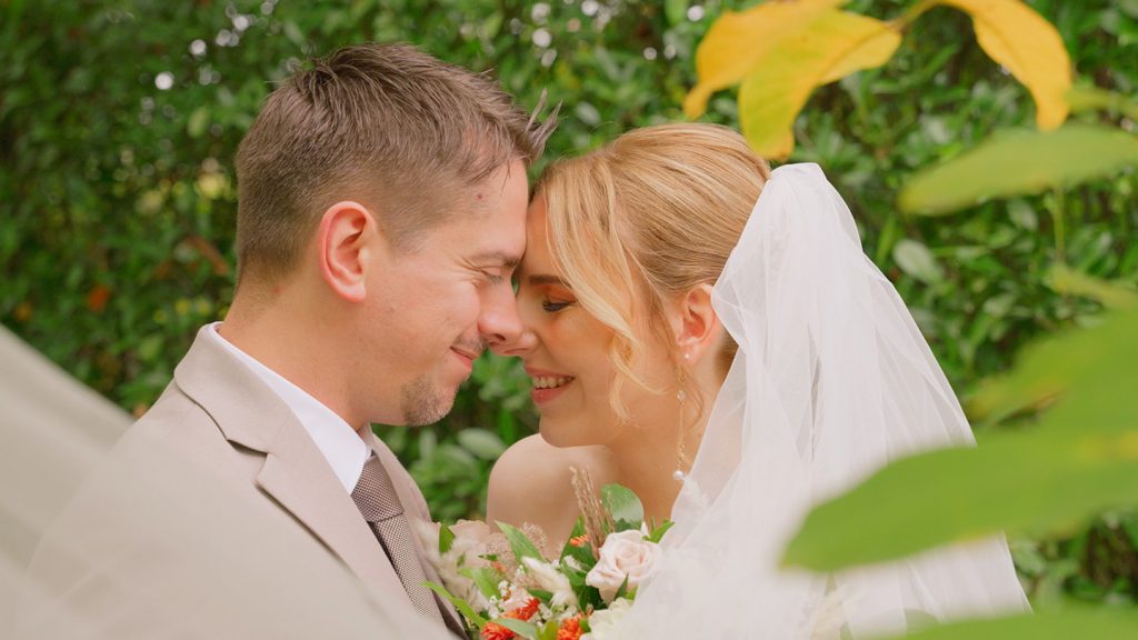 Hochzeitspaar lächelt sich im Park vom Andreashaus Niederzier an.